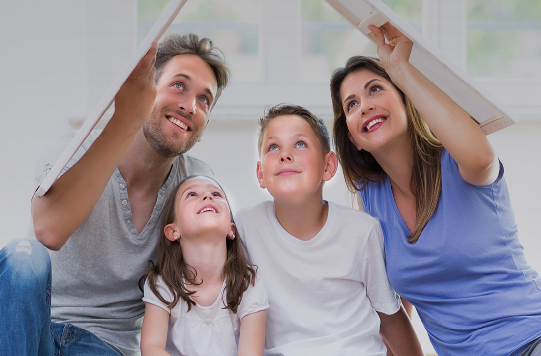 Eine Familie sitzt im Wohnzimmer auf dem Fußboden.